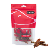 A package of dehydrated turkey strips dog treats with several strips visible in front of the package.