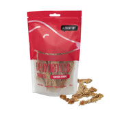 A red package of The Treatery dehydrated chicken strips dog treats, with some strips visible through the packaging window.