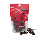 A package of The Treatery dehydrated kangaroo strips dog treats, with several strips visible in front of the package.