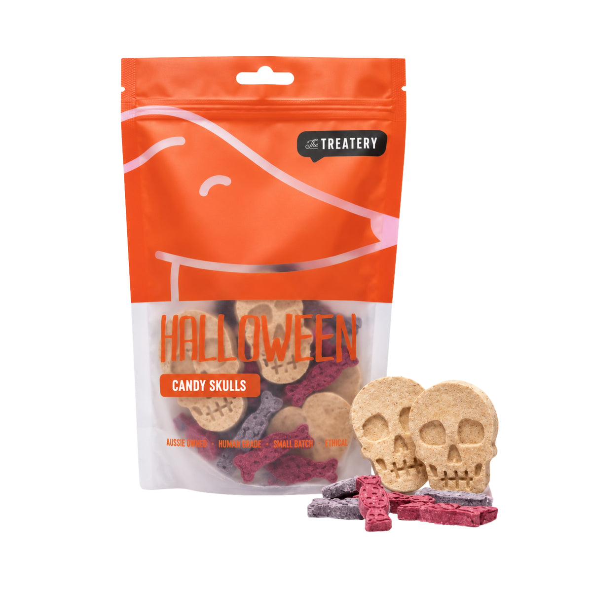 A bag of Treatery Halloween Candy Skulls dog treats on a white background, with two skull-shaped treats and several small candy treats displayed in front of the packaging.