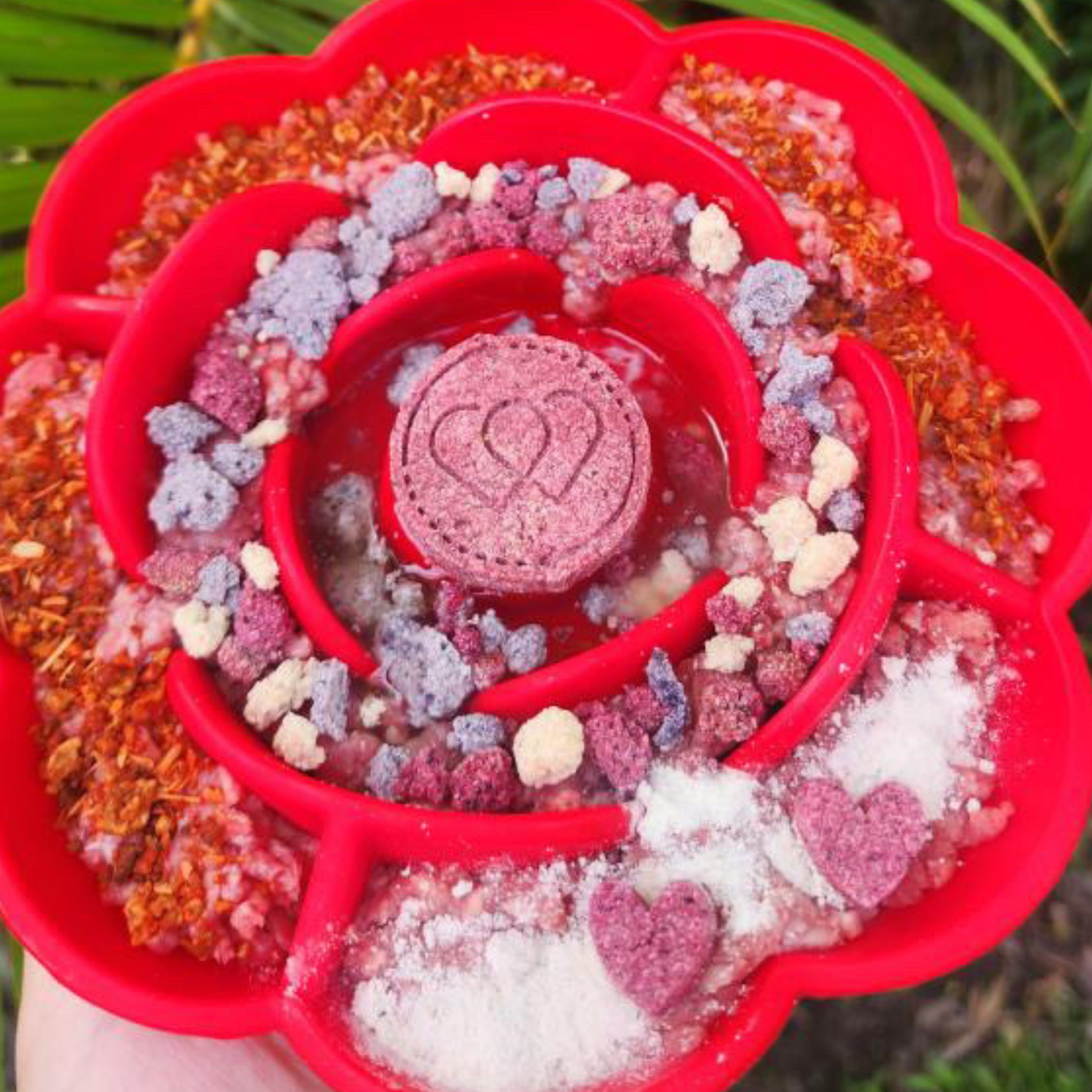 Close-up of red Rose Flower Slow Feeder filled with colorful treats encouraging dogs to lick and eat slowly for better digestion.