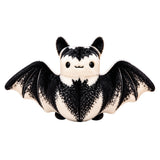 A cute plush bat toy with black and white fur, spread wings, and a smiling face, isolated on a white background.
